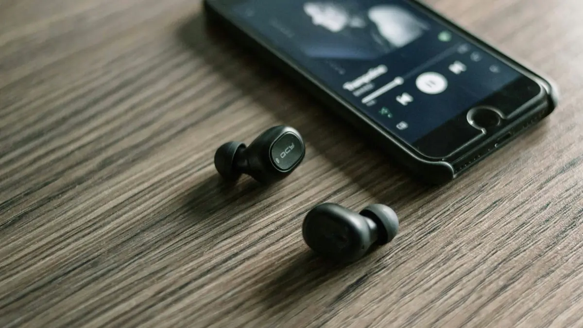 pair of Bluetooth earphones beside phone
